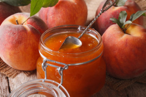Fresh peach jam in a glass jar close up on the table. Horizontal